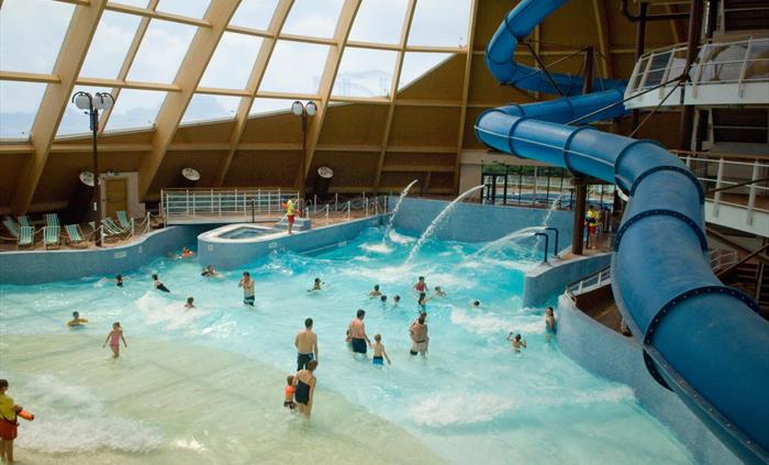A photo of the subtropical water park with slides, wild waves, outdoor spa pools, and a tranquil lazy river.
